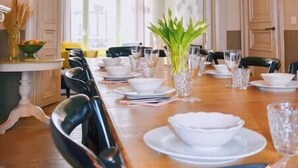 A dining room with a long wooden table set for a meal, flanked by black chairs. - Villa Les Eglantines in Belle Epoque Wijk Oostende (Oostende)