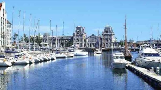 A marina with multiple boats docked, a bridge, and buildings in the background. - Villa Les Eglantines in Belle Epoque Wijk Oostende (Oostende)