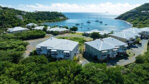 A coastal residential area with multiple two-story houses, a marina with boats, and lush greenery. - Southern Star Villa Kayaks, SUPS, Steps to Beach (Cruz Bay)