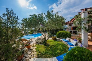Ein Swimmingpool, umgeben von Liegestühlen und einer Steinmauer.
