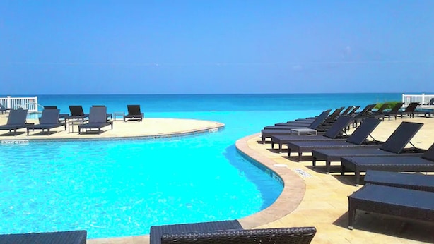 Zona de piscina amb gandules i vista a l'oceà.