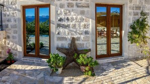Edifici de pedra amb dues finestres grans, una decoració de estrella de mar i plantes en testos.
