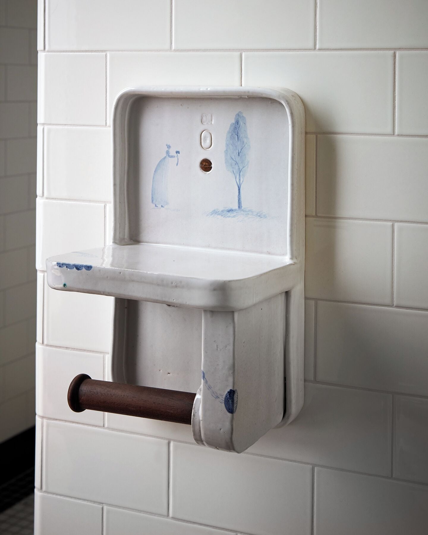 A white, wall-mounted sink with a simple design, a faucet, and a drainpipe.