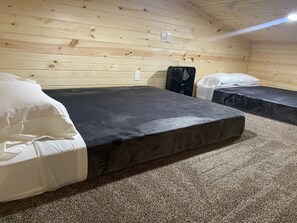 Ein Zimmer mit zwei Betten, einer Heizung und einer Holzwand.