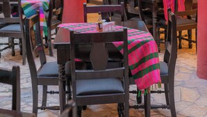 An outdoor dining area with tables and chairs, some with colorful tablecloths. - Hotel Camino Maya (Copan Ruinas)