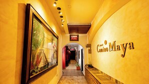 A hallway with a large mural, a sign for 'Hotel Camino Maya', and a tiled floor. - Hotel Camino Maya (Copan Ruinas)
