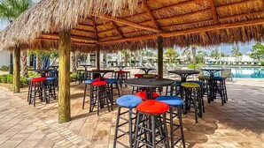 Un espace extérieur aménagé avec des parasols en chaume, des tables et des chaises.
