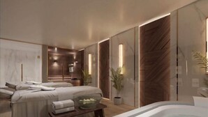A modern spa room with a large bathtub, a massage table, and a seating area with a glass table. - Ivy Cyrene Island Aqua Park Resort (Sharm El Sheikh)