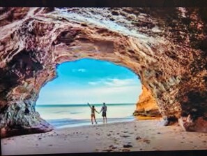 A beach scene with a natural rock archway. - Water view cottage 5 min to Cav Beach, Golf, Anne Green Gables (Stanley Bridge)