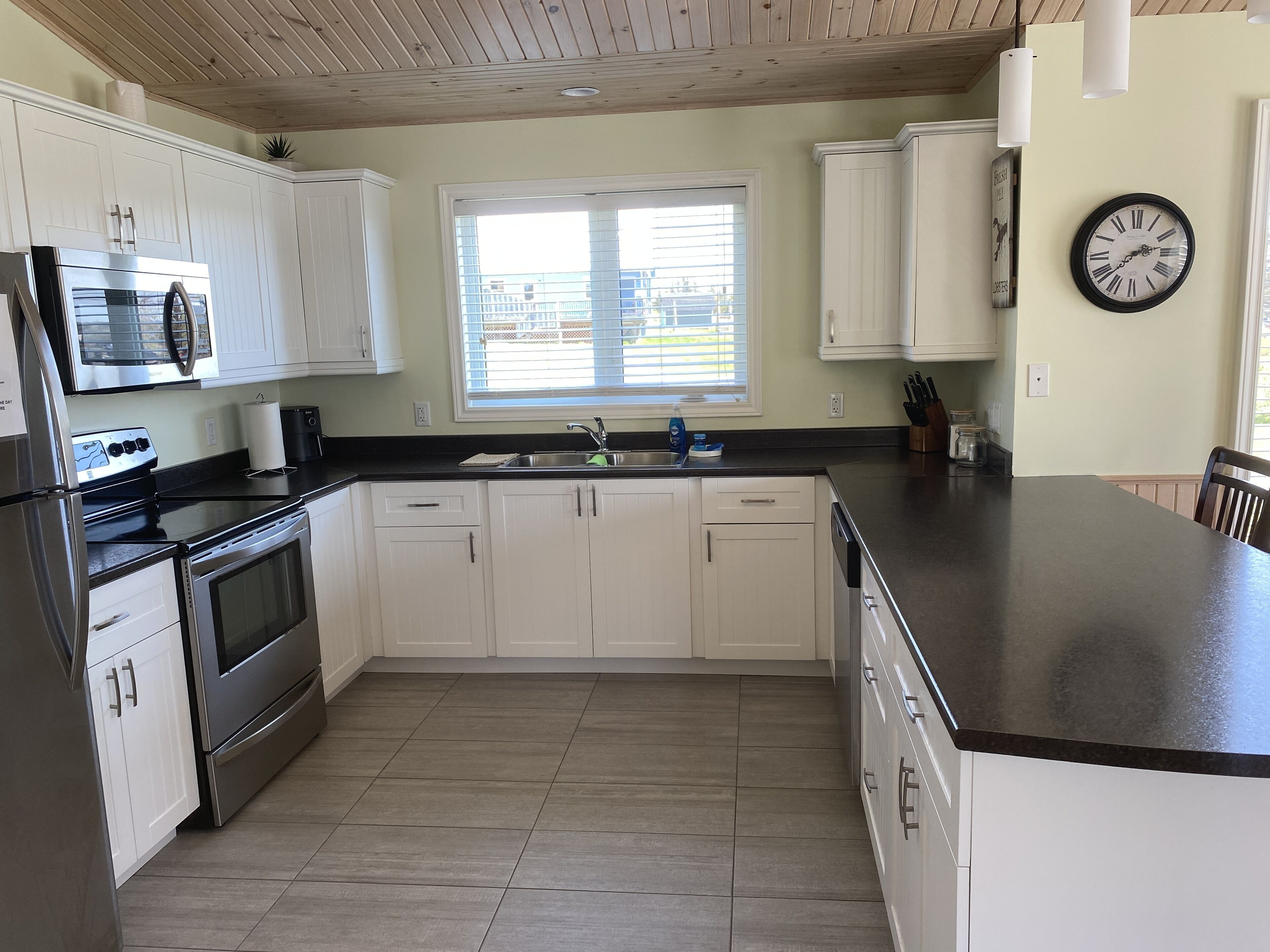 Una cocina moderna con armarios blancos, electrodomésticos de acero inoxidable y una isla grande.