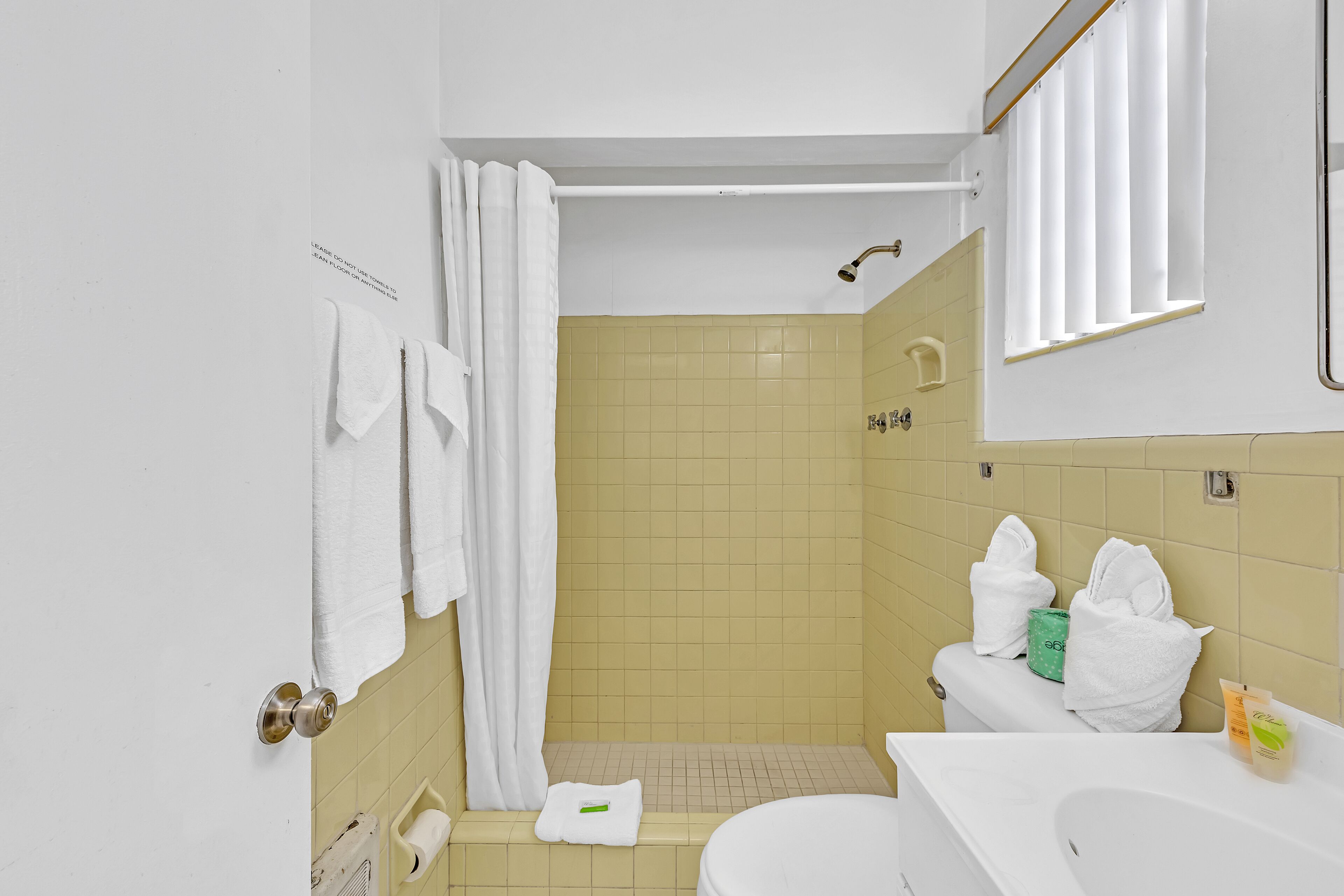 A bathroom with a shower, toilet, and sink.