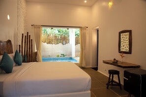 A bedroom with a large bed, a view of a pool, and a small wooden table. - Conch Resort-Luxury Private Pool Suites (Vanur)