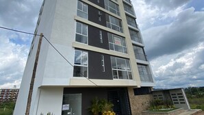 Um edifício com vários andares e design moderno, com telhado plano e grandes janelas.
