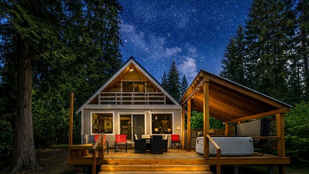 A cabin with a deck, outdoor seating, and a hot tub. - Chiwawa River Chalet 3 Bedroom Home by NW Comfy Cabins by RedAwning (Leavenworth)