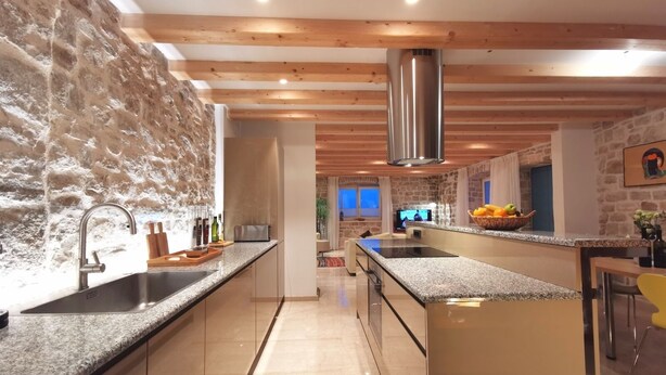 A modern kitchen with granite countertops, stainless steel appliances, and a stone backsplash. - Villa Diocletian***** Solta, Premium traditional stone house next to the sea (Rogac)