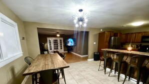 Una cocina amplia con comedor, armarios de madera y un televisor grande.