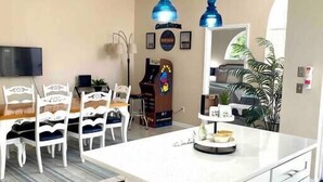Una cucina moderna con isola centrale, mobili bianchi e ventilatore a soffitto.