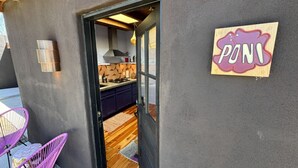A modern kitchen with dark walls, a wooden floor, and a sign reading "PONI". - Luxurious 1bd Charmer  `Poni Suite` @ La Dea (Santa Fe)