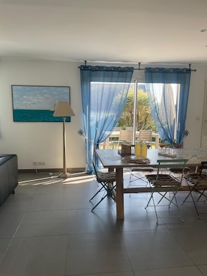 Um quarto com uma mesa de jantar, cadeiras, um sofá e um quadro na parede.