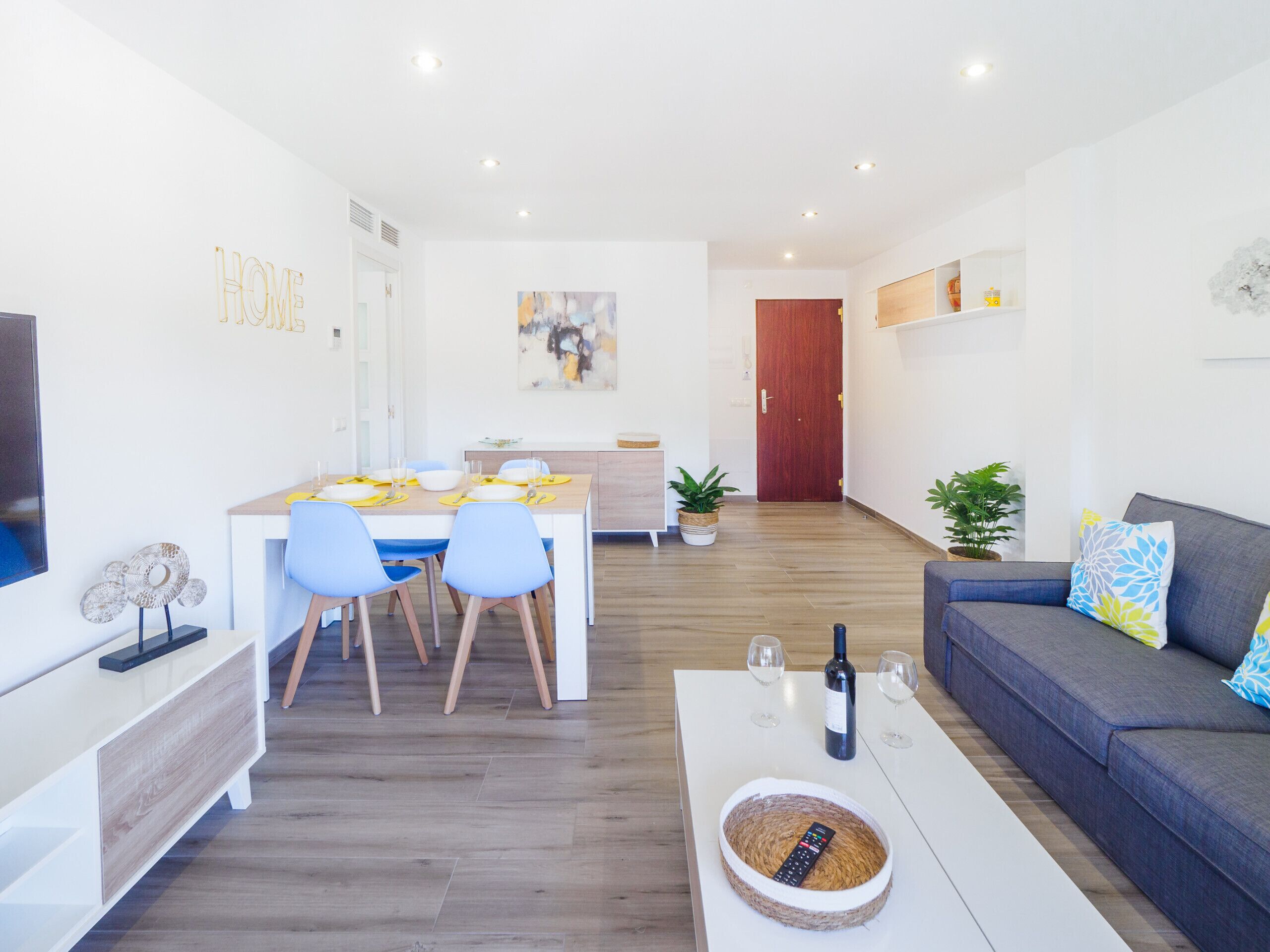 Una sala moderna con un sofá, una mesa de centro y una zona de comedor.