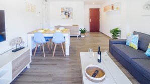 Un salon moderne avec un canapé, une table basse et un coin repas.