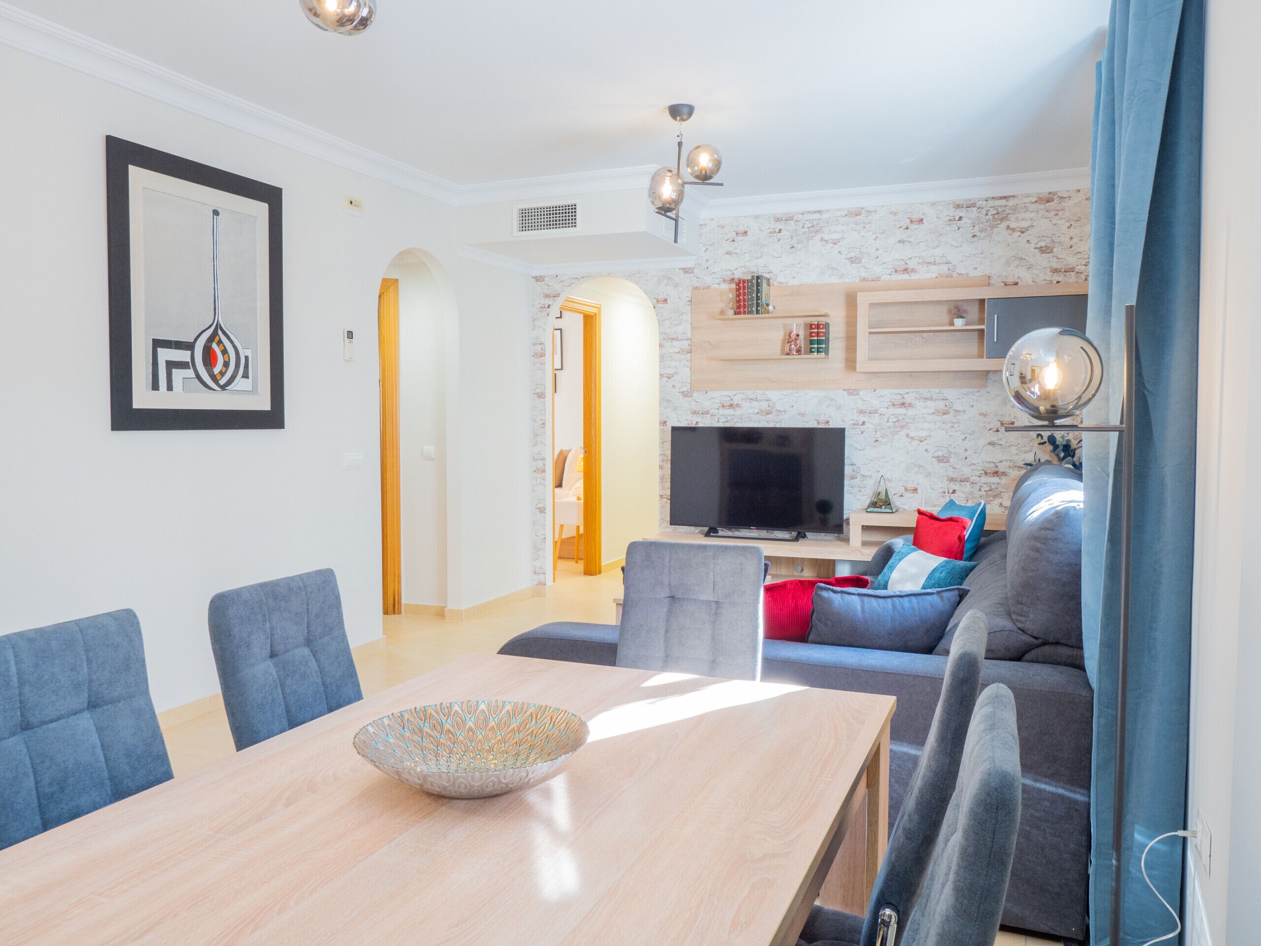 Een moderne woonkamer met een eettafel, banken en een televisie.
