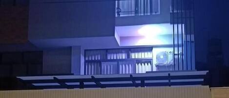 A modern building with a flat roof, multiple balconies, and a garage entrance.