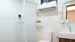 Une salle de bain moderne équipée de toilettes, d’un lavabo et d’un espace douche.