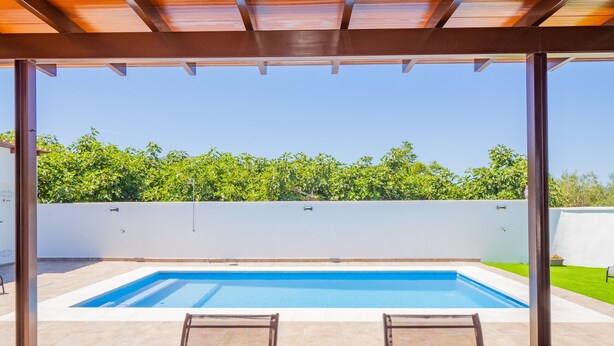 A covered outdoor swimming pool with a view of a green hedge and a clear blue sky. - Cubo's Casa Rural Marifran / Private pool / Air conditioning (Alhaurín el Grande)
