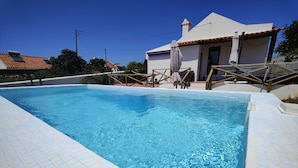 A rectangular swimming pool with clear blue water, surrounded by a tiled deck.
