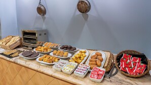 En buffet med forskellige spiser, heriblandt kager, småkager og brød.