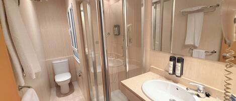 A modern bathroom with a glass-enclosed shower, a white sink, and a large mirror.