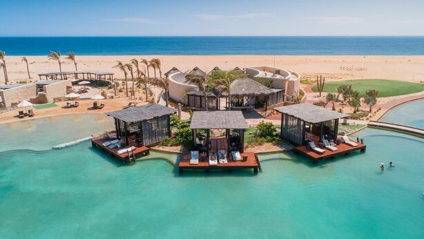 An overwater resort with multiple bungalow-style accommodations connected by walkways, a beach, and a clear blue ocean view. - LUXURY STUDIO 5 🎖️, A PARADISIAC PLACE, IN FRONT OF THE SEA  (Cabo San Lucas)