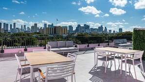 A rooftop terrace with outdoor seating and a city skyline view. - Pastel Apartments (Miami)