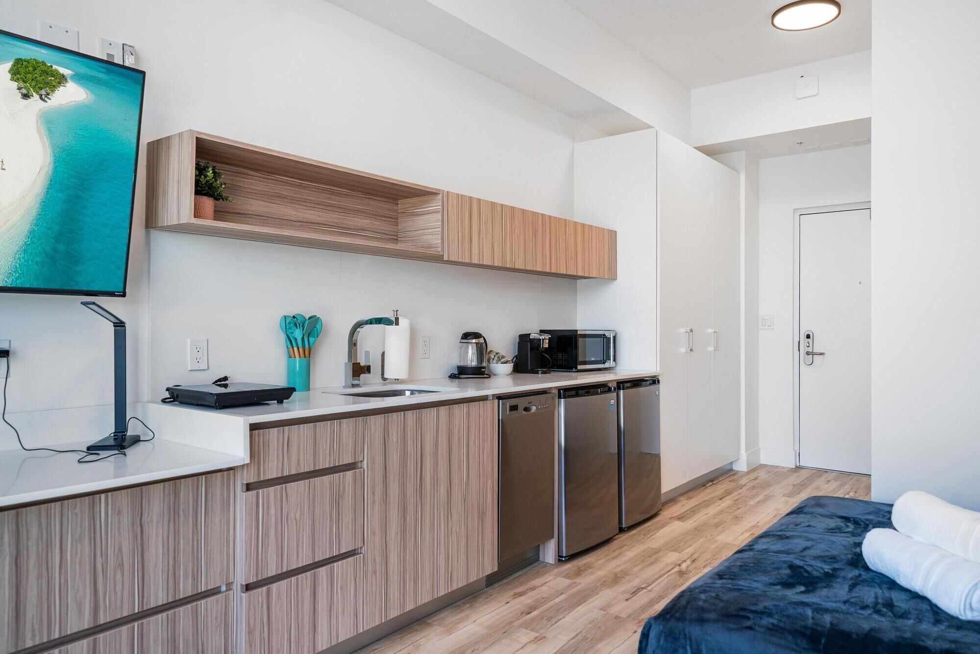 A modern kitchen with wooden cabinets, a built-in microwave, and a coffee maker.
