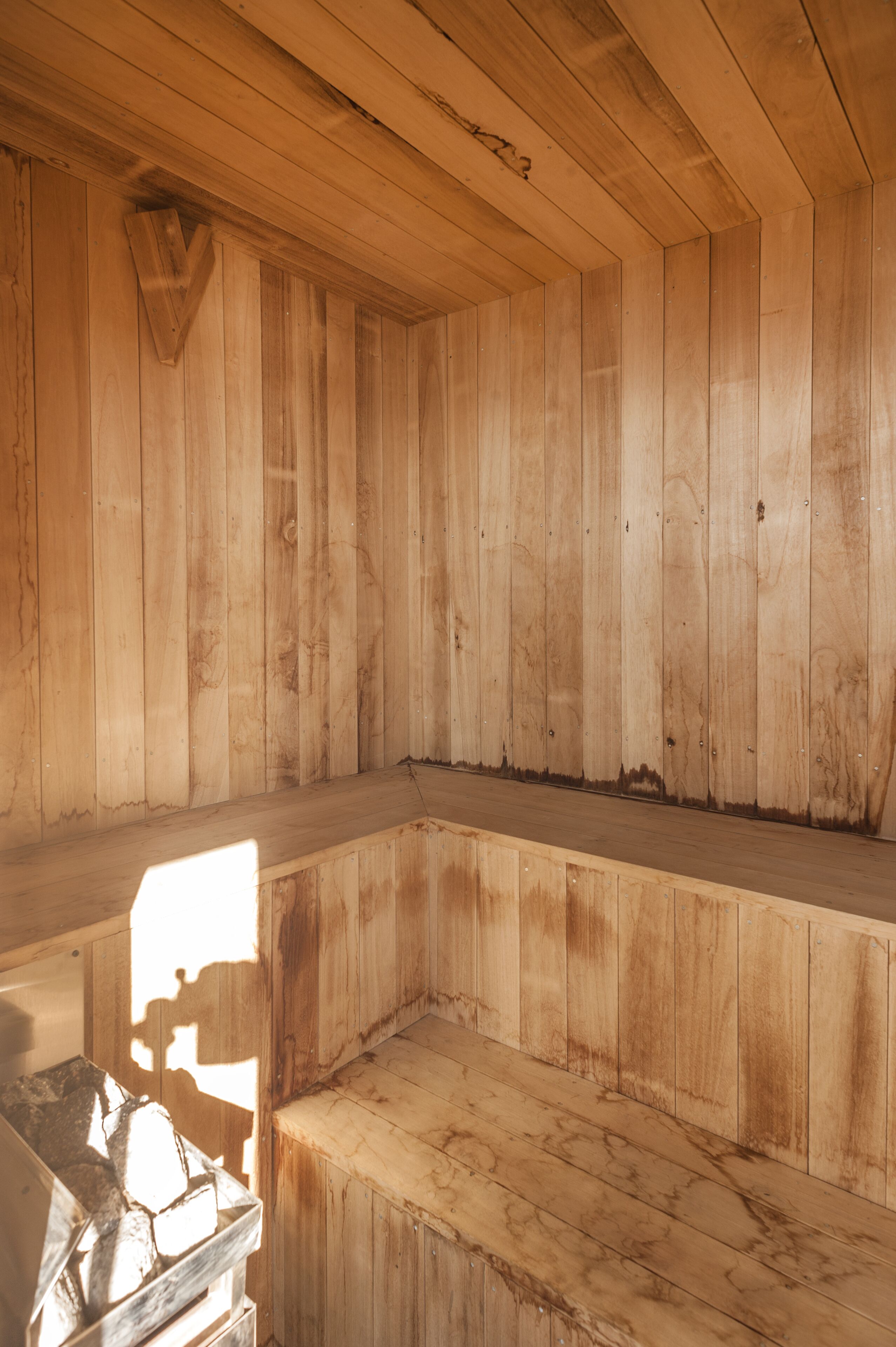 A wooden interior with a bench and a small table.