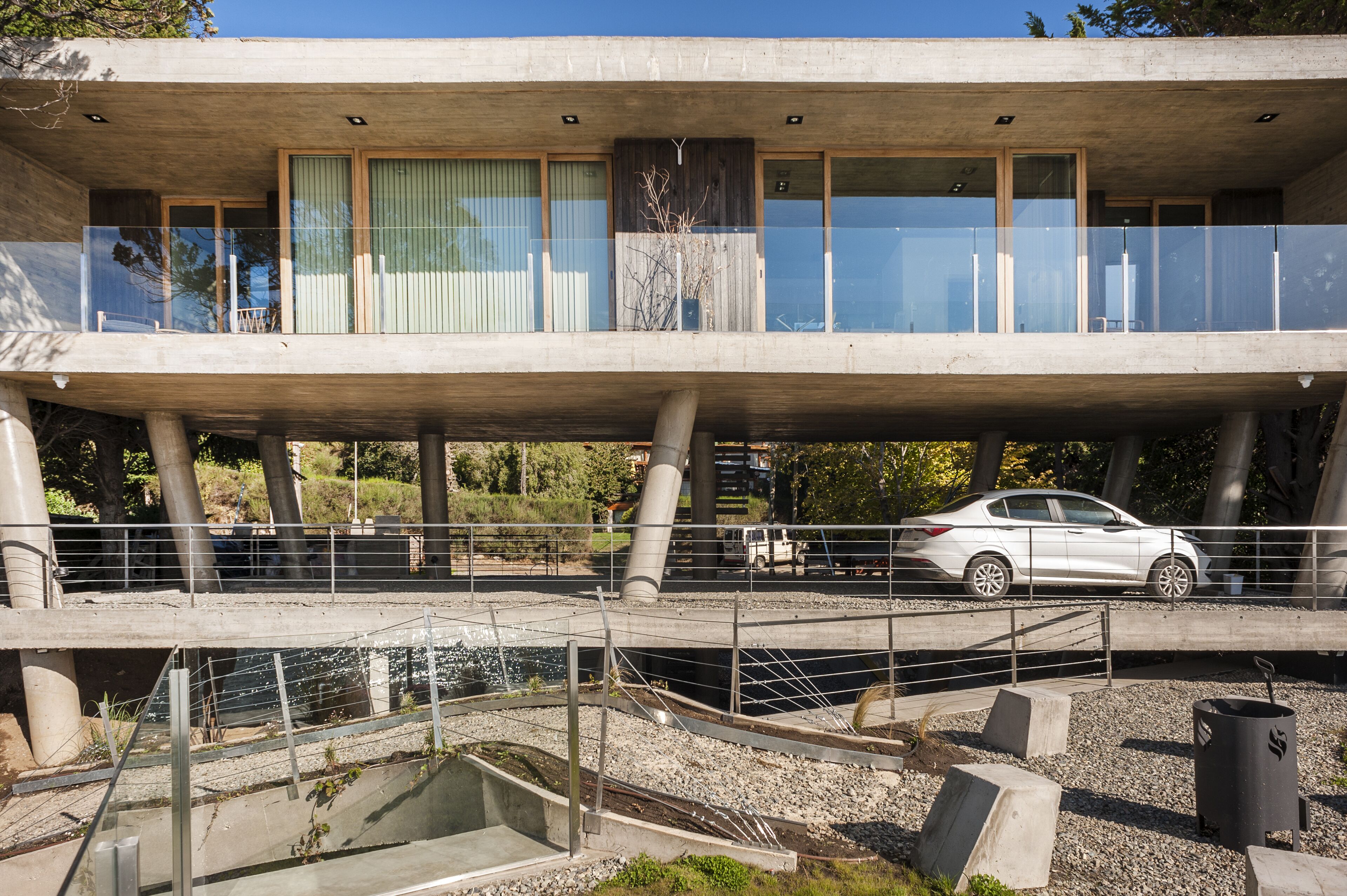 A modern building with a concrete facade, large windows, and a balcony.