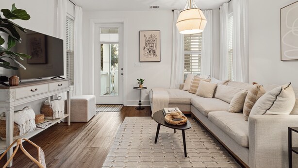 Sala moderna com sofá, TV e objetos decorativos.