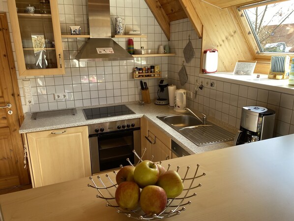 A kitchen with a stove, oven, sink, and a fruit bowl on the counter. - North Sea * Vacation home for the whole family * Dogs allowed (Wurster Nordseeküste)