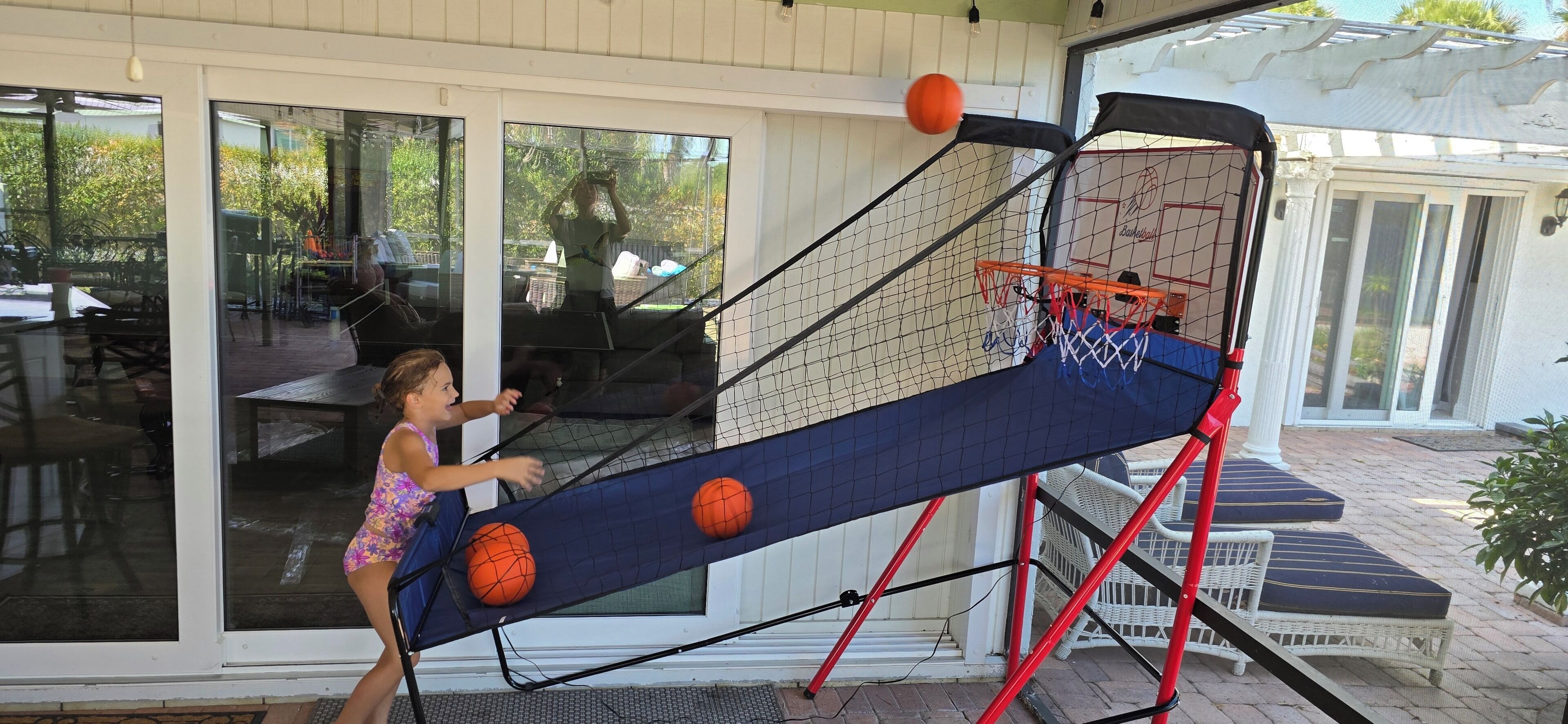 Un niño jugando al baloncesto en una cancha al aire libre con aro y red.