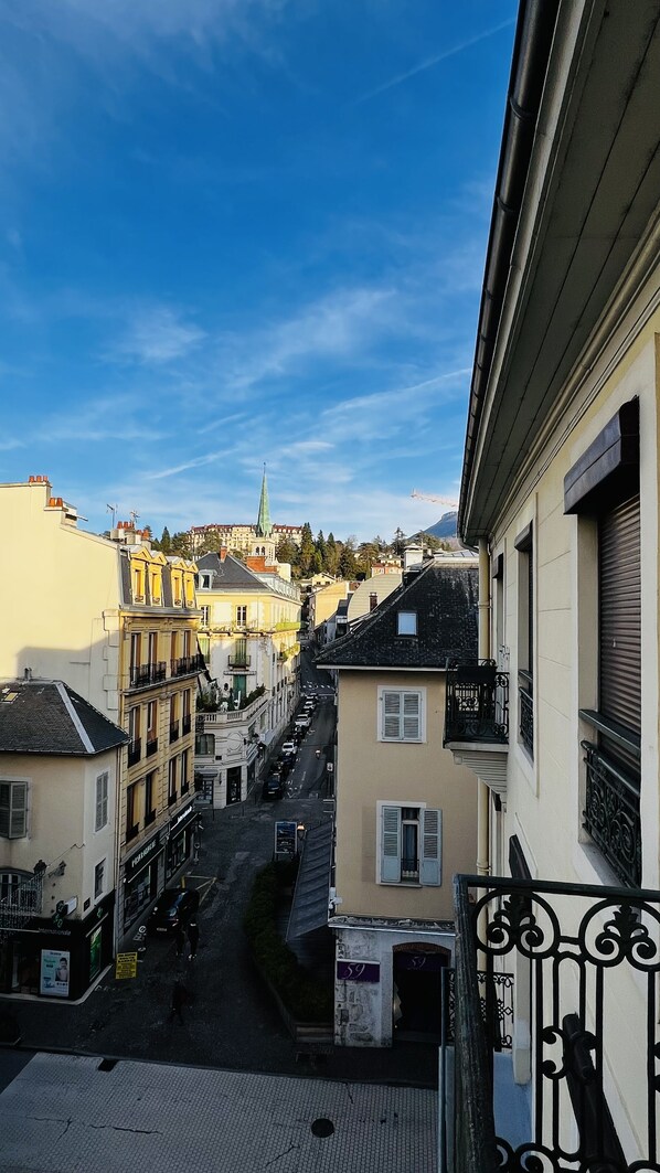A street view with buildings, a clear sky, and a distant church spire.