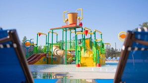 A water park with a large water slide, multiple water features, and a pool area with lounge chairs. - The Hotel at Black Oak Casino Resort (Tuolumne)