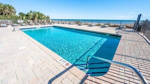 A rectangular swimming pool with clear blue water, surrounded by a tiled deck and lounge chairs. - New,Direct Oceanfront at Amazing Bluewater Resort! (Myrtle Beach)