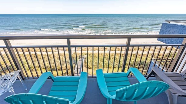 A balcony with two turquoise lounge chairs facing the ocean. - New,Direct Oceanfront at Amazing Bluewater Resort! (Myrtle Beach)