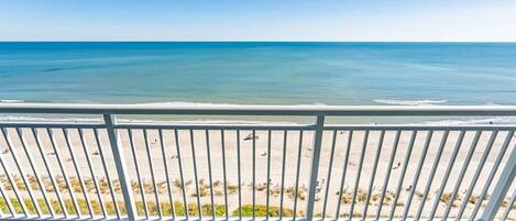 A balcony with a view of a beach and ocean.