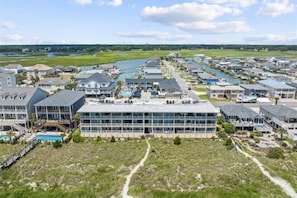 Una zona residencial costera con casas modernas, un puerto deportivo y un edificio grande con múltiples balcones.