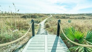 Een houten looppad dat door een natuurlandschap slingert, met aan weerszijden een touwbordes.