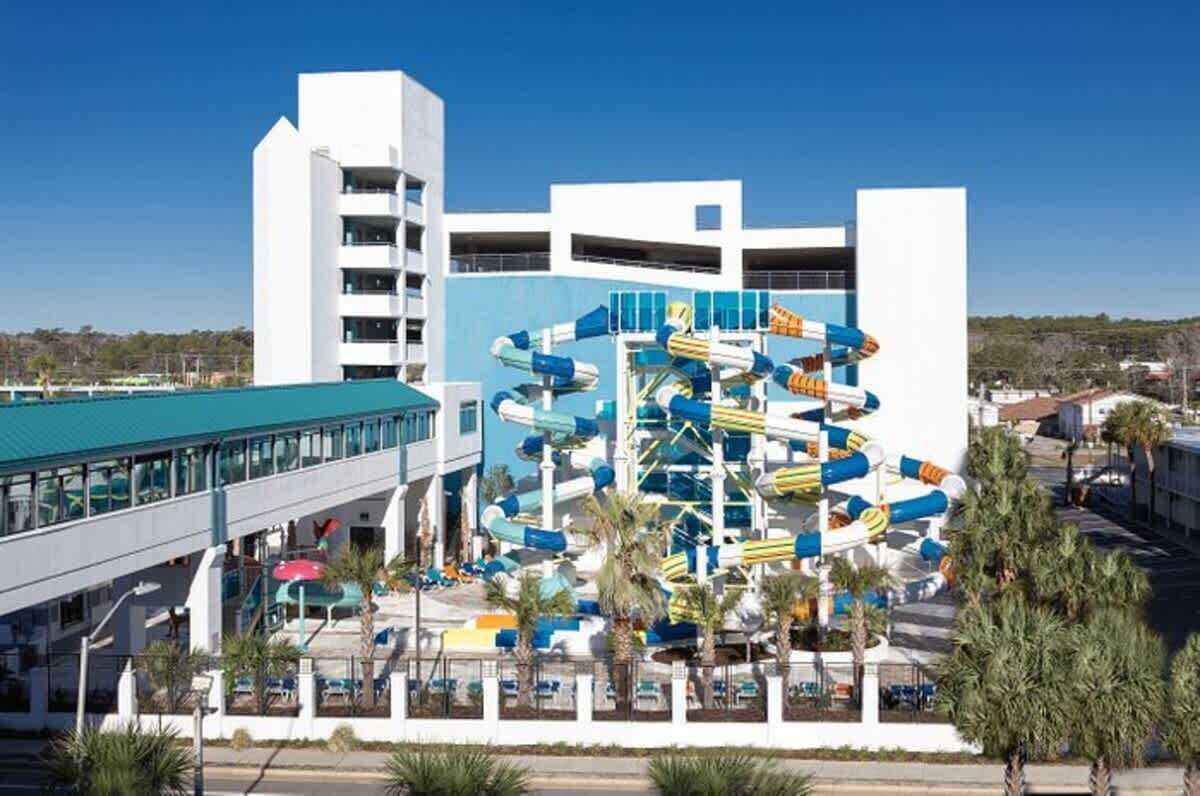 Ein modernes Hotel mit Wasserpark, einschließlich einer großen Wasserrutsche und einer überdachten Fußgängerbrücke.