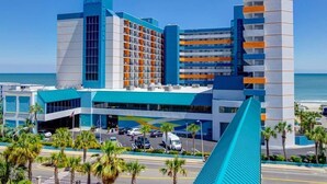 Ein modernes Hotel mit blau-weißer Farbgebung, mit mehreren Etagen und einem markanten Eingang.