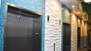 A hallway with three elevators, each marked with a number. - New Direct Oceanfront King 2BR ,Modern Decor,Pools (Myrtle Beach)